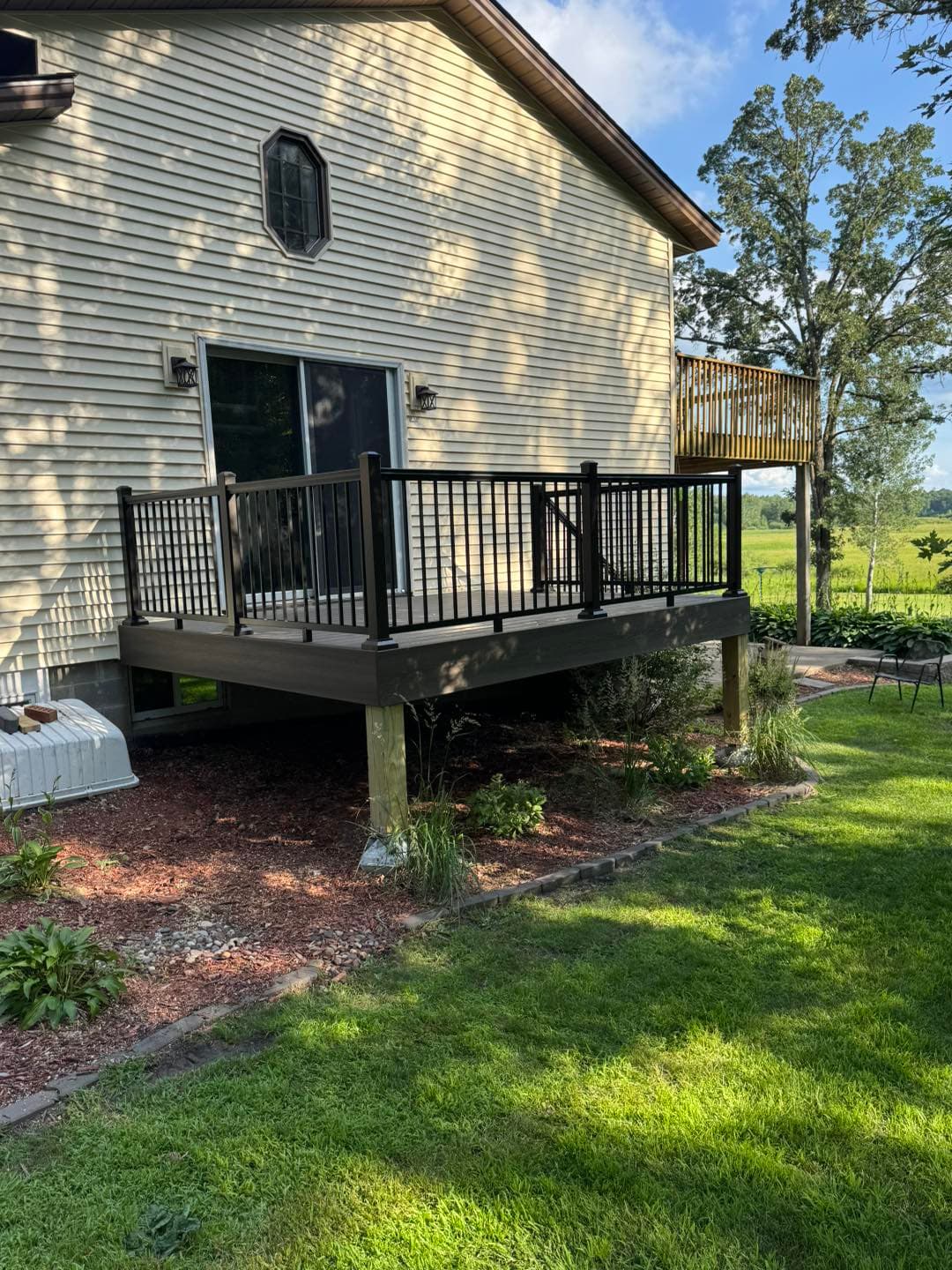 Completed deck with clean black metal railings and Minnesota countryside backdrop